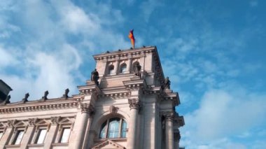 Berlin, Almanya, 1 Ekim 2022 Berlin 'deki Reichstag binasında Alman bayrağı dalgalanır. Güzel beyaz bulutlar gökyüzünde süzülür