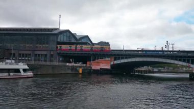 Berlin, Almanya, 1 Ekim 2022: Berlin 'deki metro istasyonundan kalkan tren köprünün üzerinde. Spree Nehri manzarası. Şehir hızlı ve elverişli nakliye