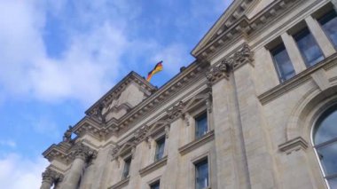 Berlin, Almanya, 2 Ekim 2022: Reichstag binasında Alman bayrağı rüzgarda dalgalanıyor