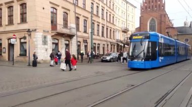 Krakow, Polonya, 15 Kasım 2022: Modern bir tramvay bir tramvay durağından kalkıyor. Çevre dostu ulaşım