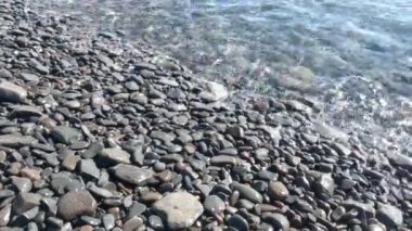 Okyanus ya da denizdeki sahile yakın çekim. Sahildeki taşlar. Volkanik kayalar. Volkanik bir adanın kıyısında
