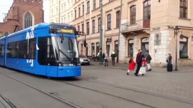 Krakow, Polonya, 14 Ekim 2022: Eski Krakow sokakları boyunca modern bir tramvayın hareketi. Şehrin temiz ve ekolojik taşımacılığı