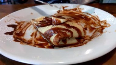 Tatlı krep yiyen bir kıza yakın çekim. Kafede nefis bir kahvaltı. Şekerler. Gözleme çatal ve bıçakla kesilir.