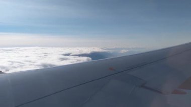 Bulutların manzarası ve uçak penceresinden kanat manzarası. Uçuş. Hava yolculuğu