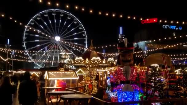カトヴィツェ ポーランド 2022年11月21日 夜の混雑したクリスマスマーケットの眺め 観光客や地元の人々の群衆は 市場広場の周りを歩く 観覧車の眺め — ストック動画