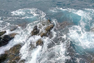 Adanın yakınındaki mavi dalgaların ve kayaların en üst manzarası