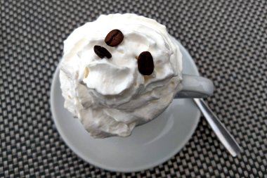 Krem şantili bir fincan taze kahvenin üst görüntüsü.