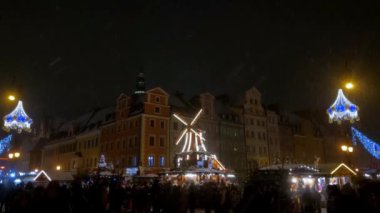 Wroclaw, Polonya, 27 Kasım 2022: Akşam Noel pazarı. İnsanlar dinleniyor, Noel hediyeleri ve yiyecekler alıyor.