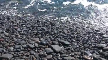 Dalgalar kayalık bir sahilde yuvarlanır. Taşlar Atlantik Okyanusu 'nun dalgaları tarafından yıkanır. Okyanustaki ada
