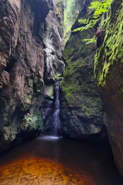 Between the two rocks flows a small waterfall