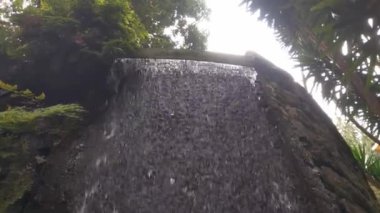 A stream of cold clear water flows from a height. A small waterfall