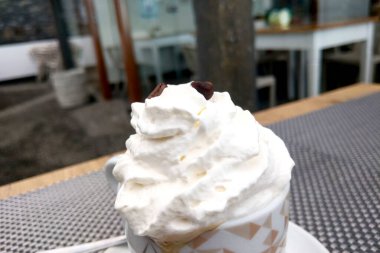 Whipped cream on fresh coffee. A cup of coffee