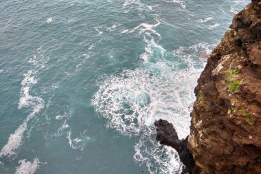 A picturesque view of the waves of the sea or the ocean and the mountainside