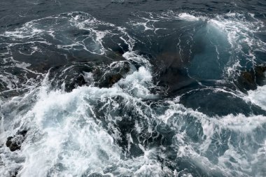 View from a drone on the turquoise waves of the sea or ocean. The power of water