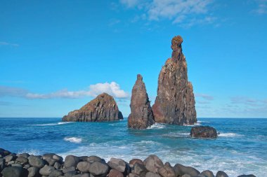 Suda küçük kayalar var. Su kayaları ve adanın kıyılarını yıkar.