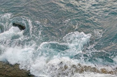 View from above on the waves of the sea or ocean and the coast
