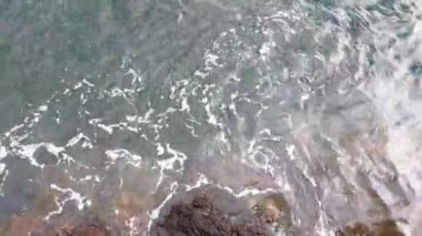 View from a height on the waves of the sea or ocean and rocks