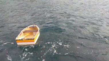 Okyanusta ya da denizde boş bir tekne. Dalgalar tekneyi sallar