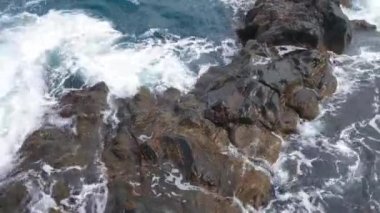 View from a height of the waves crashing against the rocks