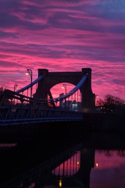 Wroclaw, Polonya, 10 Ağustos 2022: nehrin karşısındaki eski köprüye bakan güzel gün batımı