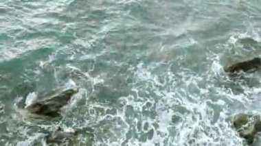 Kayaların ve kayaların üzerindeki dalgaların kırılma sesi.