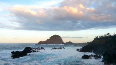 Madeira Adası kıyılarında güzel bir gün batımı. Dalgalar kayalık kıyıya çarpar