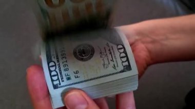 Kız elinde bir paket dolar tutuyor.