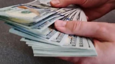 Elindeki kız parayı bir vantilatörle yatırıyor. Bir paket dolar.