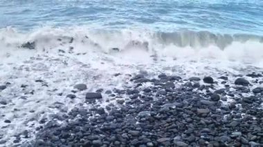 Deniz dalgaları kayalık sahilde yuvarlanıyor. Doğanın gücü.