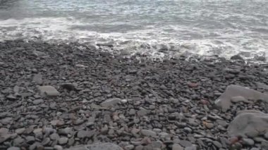 Deniz dalgaları kıyı boyunca yuvarlanır. Rocky sahili