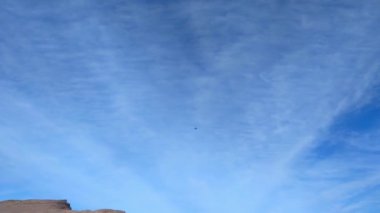 Mavi gökyüzüne karşı uçan bir uçağın alt görüntüsü