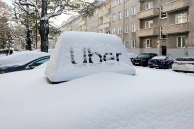 Wroclaw, Polonya, 1 Aralık 2023: karla kaplı taksi ve Uber tabelası