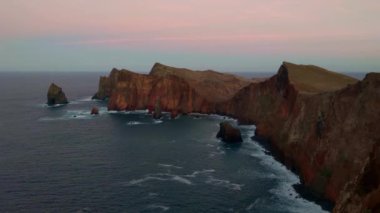 Adanın kayalık kıyıları Güneş ışınları altında