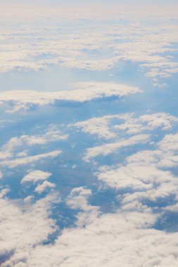 Uçan bir uçağın penceresinden beyaz bulutların görüntüsü