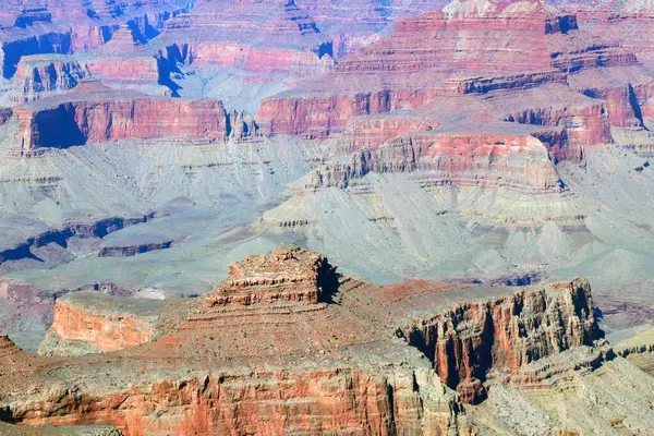 The image shows the immense scale and depth of the Grand Canyon, with layers of rock formations visible from top to bottom. The Grand Canyon stretches far into the distance, showcasing the natural beauty of this iconic landmark.