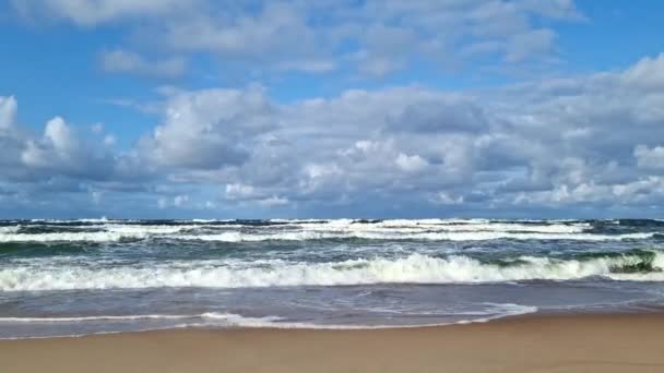 这个场景捕捉了海浪在沙滩海岸线上碰撞时的动态运动 伴随着令人印象深刻的翻滚的云彩在天空中穿行 凸显了大自然的美丽 — 图库视频影像