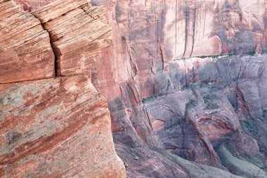 Uçsuz bucaksız bir kanyona bakan bir uçurumun kenarında güvenle duran bir adam. Kayalık arazi ve dik düşüş cesur duruşu için dramatik bir zemin oluşturur..