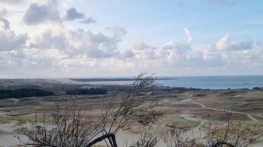 Uçsuz bucaksız okyanus manzarası bir tepenin üstünden aşağıya doğru uzanıyor. Dalgalar kıyıya çarpıyor ve deniz kuşları uzaklardan süzülüyor. Ufuk uçsuz bucaksız uzanıyor, sonsuzluk ve güzellik hissi yaratıyor..