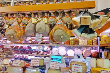 Bolonya, İtalya, 15 Mayıs 2024: İtalyan şarküterisi bir dizi pişirilmiş et ve çeşitli peynir sergiliyor. Seçim prosciutto, pecorino ve diğer sanatsal ürünleri içerir. Ekranda geleneksel mutfak lezzetleri vurgulanıyor. 