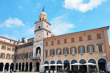 Modena, İtalya, 12 Mayıs 2024: Tanınmış bir saat kulesi, tarihi mimari ve açık hava kafeleri ile İtalya şehir meydanını büyülemek. Atmosfer davetkar, burayı turizm ve eğlence için ideal bir yer yapıyor..