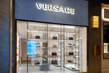 Bologna, İtalya, 15 Mayıs 2024: Versace mağaza vitrinlerinde zarif bir şekilde tasarlanmış raflarda çeşitli lüks el çantaları ve aksesuarlar sergilenmektedir. Parlak, sofistike ekran markanın imzasını vurgular, Hig 'e görsel olarak çekici bir bakış sunar.