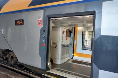 Bolonya, İtalya, 15 Mayıs 2024: Erişilebilir kapısı olan modern tren, güvenlik levhası ve iç mekan manzarası. Çağdaş demiryolu taşımacılığının kolaylığı ve tasarımını vurgular, erişilebilirlik, konfor ve verimliliğe odaklanır