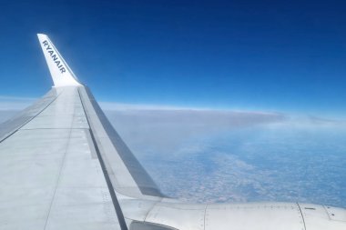 Bologna, İtalya, 18 Mayıs 2024: Avrupa 'nın yükseklerindeki bir ryanair uçağından çarpıcı bir hava manzarası. Görüntü sakin mavi gökyüzü, yeryüzünün eğriliği ve aşağıdaki uçsuz bucaksız arazi. Seyahatle ilgili içerik ve macera için mükemmel