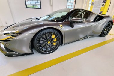 Modena, İtalya, 12 Mayıs 2024: Çağdaş bir galeride gösterilen gösterişli gri ferrari supercar. İçinde aerodinamik tasarım, yüksek performanslı tekerlekler ve premium bitiş var. Meraklılar için ideal, lüks otomotiv mühendisliği ve tasarım mükemmelliği sergileniyor.