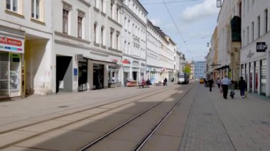 Gorlitz, Almanya, 13 Nisan 2024: Dükkan ve kafelerle dolu hareketli bir kentsel caddenin yer aldığı tarihi Avrupa şehir merkezi. Açık, güneşli bir gün binaların mimari cazibesini vurguluyor.