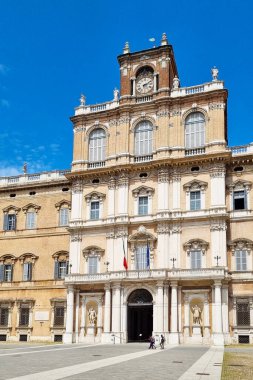 Modena, İtalya, 12 Mayıs 2024: Klasik mimarisi ile çarpıcı bir tarihi italyan hükümet binası, belirgin bir saat kulesi ve açık mavi gökyüzüne karşı kurulmuş karmaşık cepheler. Seyahat, tarih, mimari ve eğitim için ideal 