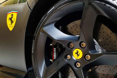 Modena, İtalya, 12 Mayıs 2024: Ferrari 'nin tekerinin yakın çekim fotoğrafları ikonik sarı ferrari logosu, ayrıntılı siyah teller ve yüksek performanslı fren kalibreleri sergilenmektedir. Lüks, titiz mühendislik ve otomotiv mükemmeliyeti, mükemmelliği vurguluyor.