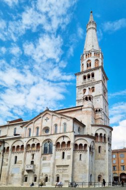 Modena, İtalya, 12 Mayıs 2024: İkonik ghirlandina kulesinin yer aldığı Modena Katedrali, İtalya 'da Romanca mimarinin önemli bir örneğidir. Katedral, dağınık bulutlu mavi bir gökyüzüne karşı dimdik duruyor. Karmaşık ortaçağ sto 'ları sergiliyor.