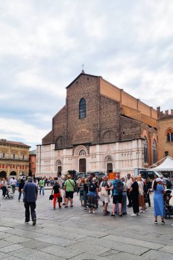 Bolonya, İtalya, 18 Mayıs 2024: Turistler etkileyici bir tarihi kilise cephesi önünde hareketli bir şehir meydanında toplandılar. Sahne, tarihi mimari ve canlı sokak yaşamının bir karışımını içeriyor ve bu da onu seyahat rehberliği veya promosyon için ideal kılıyor.