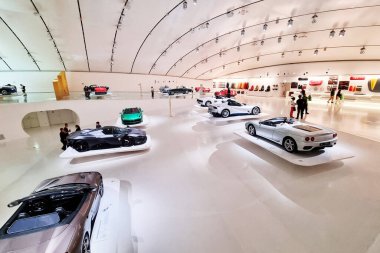 Modena, İtalya, 14 Mayıs 2024: Lüks bir spor araba müzesi geniş ve fütüristik bir galeride zarif bir şekilde sergilenen klasik ve modern otomobillere sahiptir. Pürüzsüz, beyaz iç mekan modern ışıklandırmayla aydınlatılıyor. Gelişmiş ATM 'yi geliştiriyor.